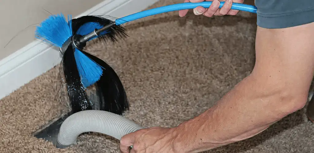 Dryer vent cleaning technician brushing lint from a vent line in Jacksonville, FL