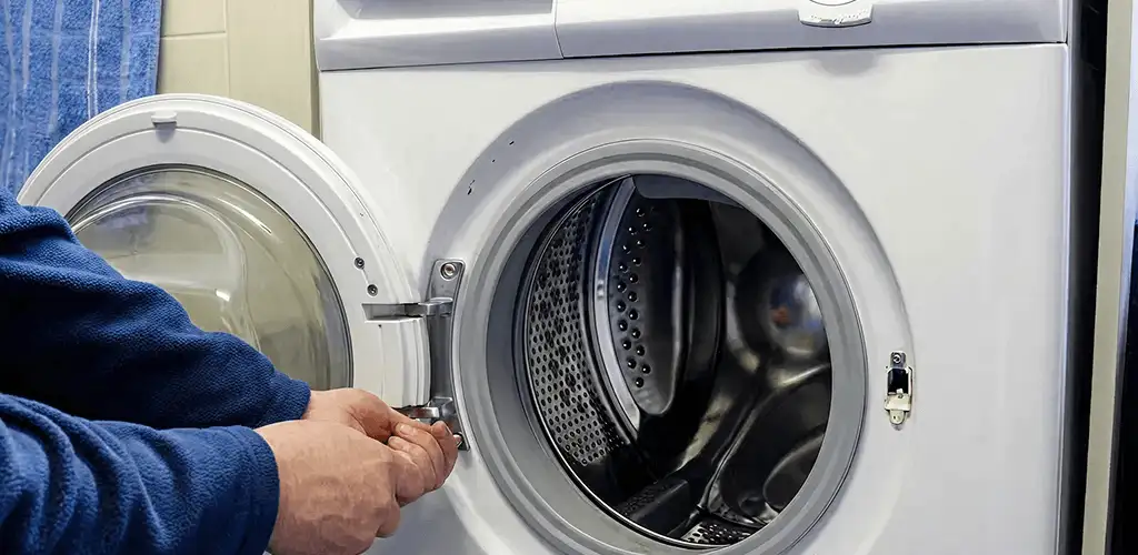 Washing machine repair handyman checking a front-load washer door and latch in Jacksonville, FL