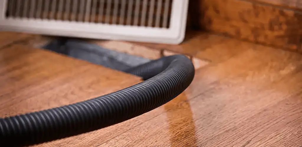 Air duct cleaning hose inserted into a floor vent for ductwork cleaning in Jacksonville, FL
