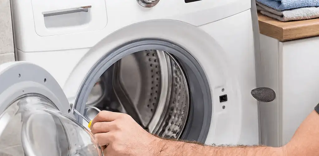 Handyman repairing a front-load washing machine and inspecting the drum in Jacksonville, FL
