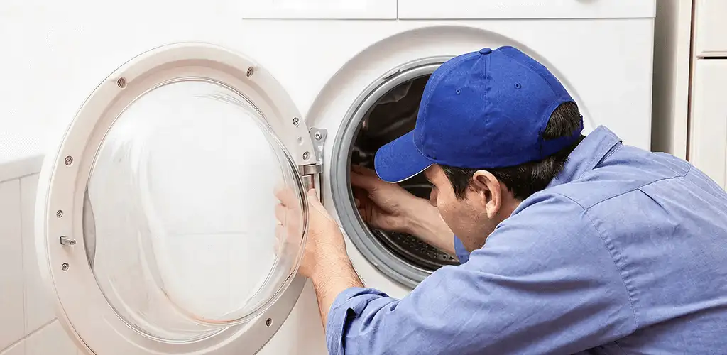 Washing machine repair handyman inspecting a front-load washer drum in Jacksonville, FL