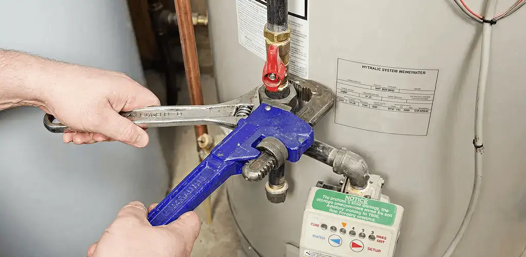 Water heater repair technician tightening the shutoff valve and supply line in Jacksonville, FL